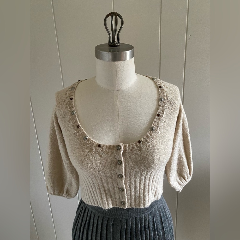 Soft chenille scoop neck cropped cardigan w puff sleeve and beaded neckline.